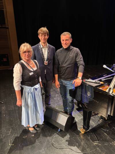 Bürgermeister Dr. Felix Kempf mit Organisatorin Manuela Sitz (Gemeinde Planegg) und dem Musikkabarettisten Martin Schmitt