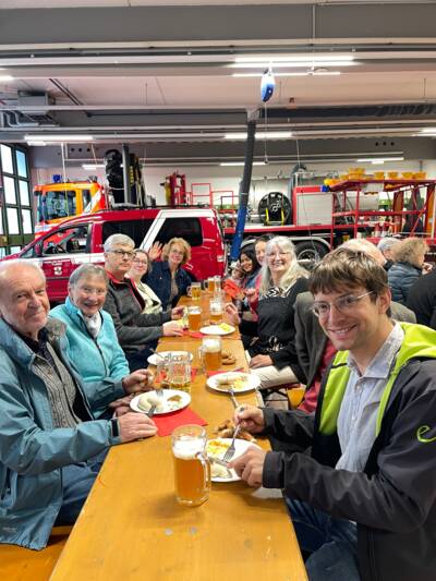 Delegation aus Meylan und Gastgeber der Gemeinde Planegg sitzen am Biertisch beim traditionellen Weißwurstessen bei der Freiwilligen Feuerwehr Planegg im Mai 2026