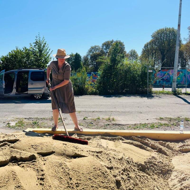 Judith Grimme hakt den aufgeschütteten Sand für den Planegger Sommergarten